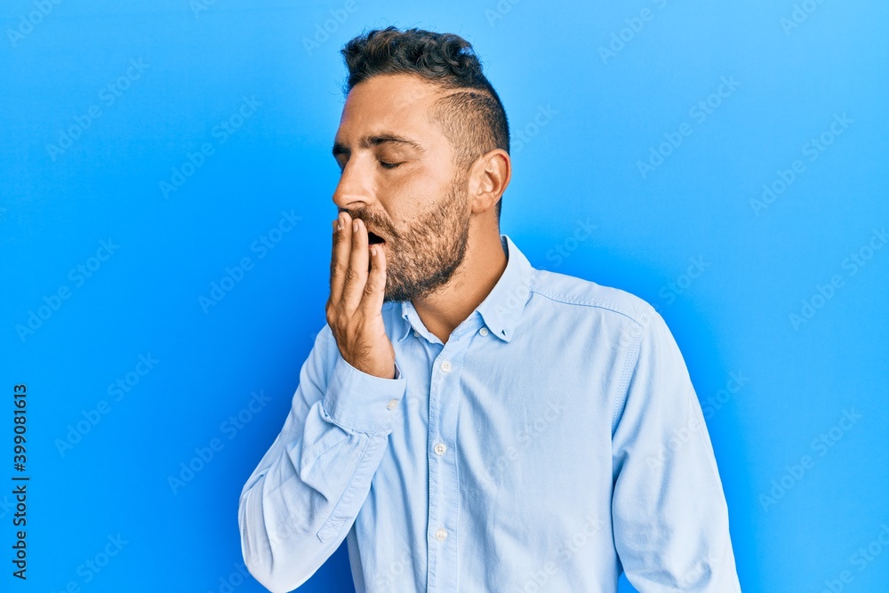 Handsome man with beard wearing casual clothes bored yawning tired covering mouth with hand. restless and sleepiness. Handsome man with beard wearing casual clothes bored yawning tired covering mouth with hand. restless and sleepiness.