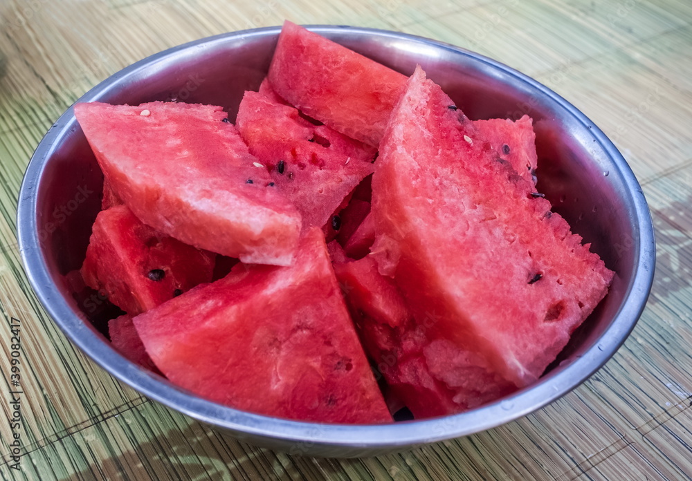 Watermelon slices without a crust in a metal dish close-up on the table background Watermelon slices without a crust in a metal dish close-up on the table background