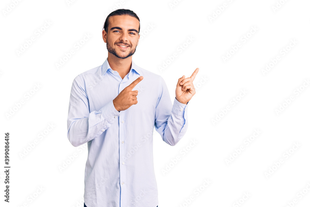 Young handsome man wearing business clothes smiling and looking at the camera pointing with two hands and fingers to the side. Young handsome man wearing business clothes smiling and looking at the camera pointing with two hands and fingers to the side.