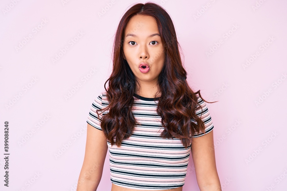 Young beautiful chinese girl wearing casual clothes scared and amazed with open mouth for surprise, disbelief face Young beautiful chinese girl wearing casual clothes scared and amazed with open mouth for surprise, disbelief face