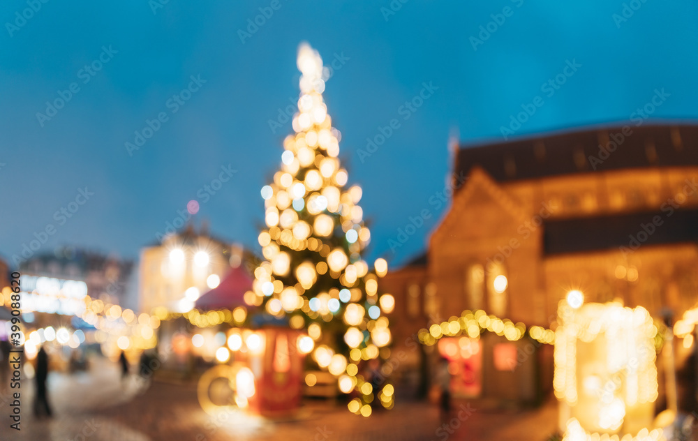 Riga, Latvia. Blurred Bokeh Background Xmas Christmas Tree And Trading Houses Riga, Latvia. Blurred Bokeh Background Xmas Christmas Tree And Trading Houses