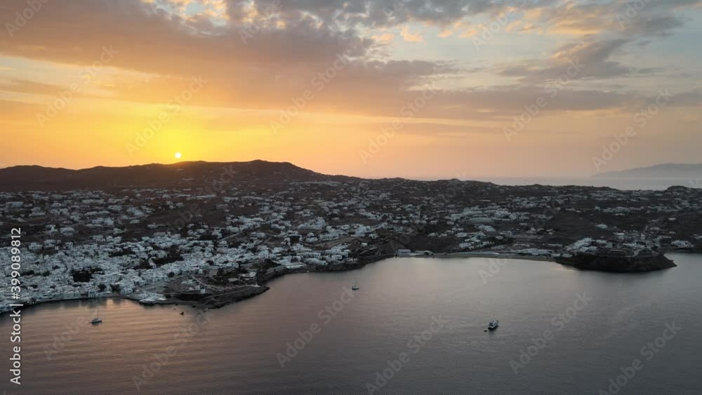 Aerial panning shot of a spectacular sunrise behind Mykonos island in Greece Aerial panning shot of a spectacular sunrise behind Mykonos island in Greece