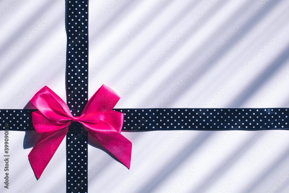 Pink bow on dotted black ribbon. Gift, celebration background concept Pink bow on dotted black ribbon. Gift, celebration background concept