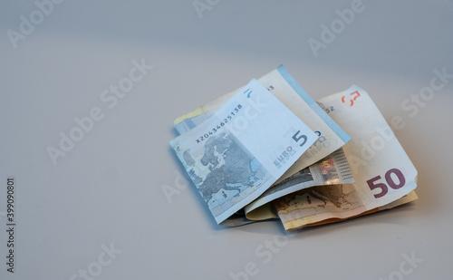 Cash or Euro paper money notes on light gray background. Folded pocket money earnings. Copy space. photo