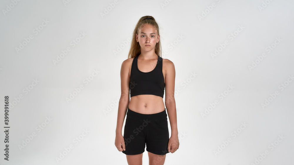 Portrait of cute sportive girl child in sportswear looking at camera, while posing isolated over white background Portrait of cute sportive girl child in sportswear looking at camera, while posing isolated over white background