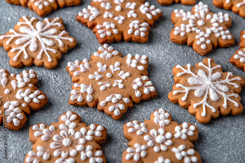 Christmas homemade gingerbread cookies in the shape of snowflakes and herringbone on a blue background. Holiday sweets for decoration and gifts.