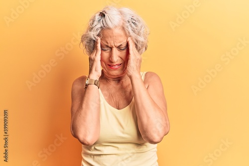 Senior grey-haired woman wearing casual clothes with hand on head, headache because stress. suffering migraine.