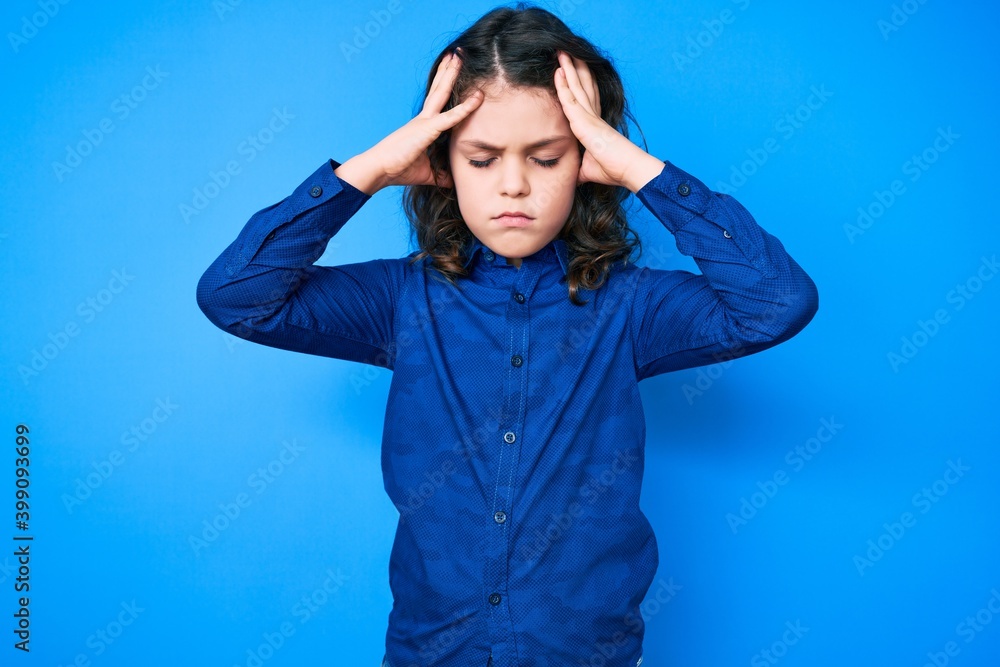 Cute hispanic child with long hair wearing casual clothes suffering from headache desperate and stressed because pain and migraine. hands on head. Cute hispanic child with long hair wearing casual clothes suffering from headache desperate and stressed because pain and migraine. hands on head.