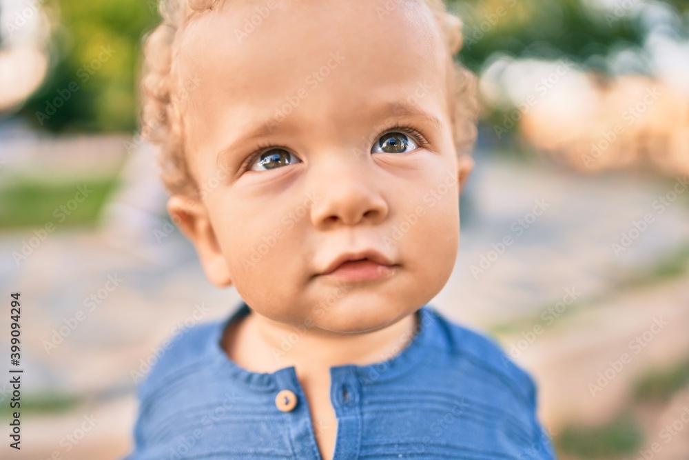 Cute and happy little boy having fun at the park on a sunny day. Beautiful blonde hair male toddler playing outdoors Cute and happy little boy having fun at the park on a sunny day. Beautiful blonde hair male toddler playing outdoors