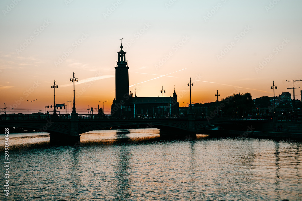 Beautiful view of the Stockholm City Hall during sunrise. Contrasting dark silhouette against the orange sky. Stockholm, Sweden