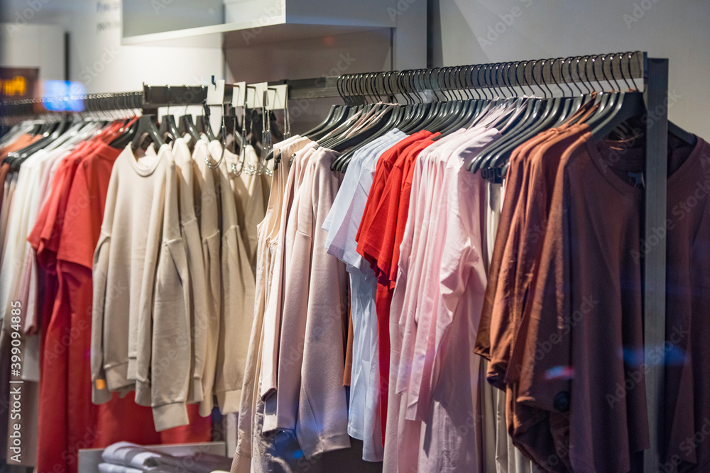 Women clothing on hangers in a mall - shopping in mall concept Women clothing on hangers in a mall - shopping in mall concept