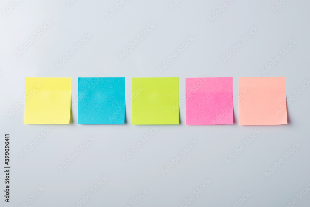 Sticky notes of different colour on white magnetic board. Copy space picture of note pads