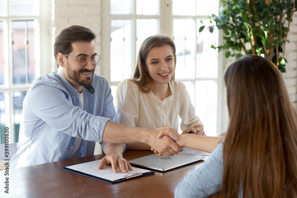 Smiling male employer shake hand of female job candidate or applicant after successful interview in office. Happy man recruiter handshake get acquainted or close deal with client. Employment concept. Smiling male employer shake hand of female job candidate or applicant after successful interview in office. Happy man recruiter handshake get acquainted or close deal with client. Employment concept.
