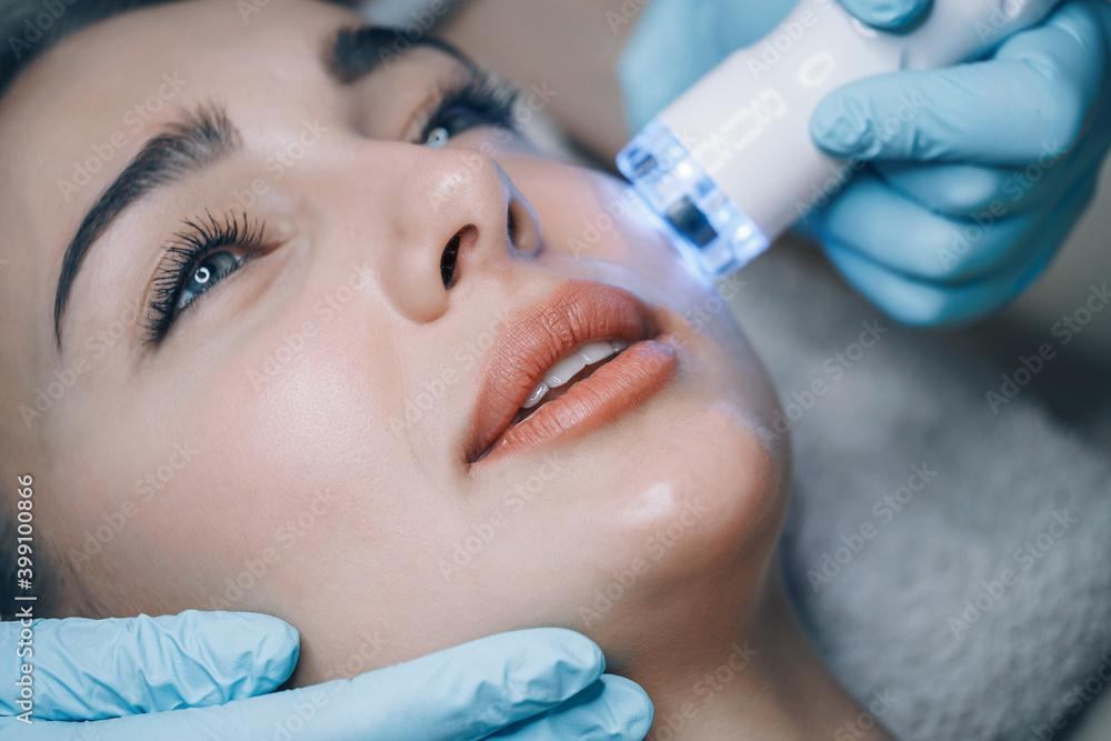 doctor performs cosmetic procedures in a beauty salon on the face of a young woman doctor performs cosmetic procedures in a beauty salon on the face of a young woman