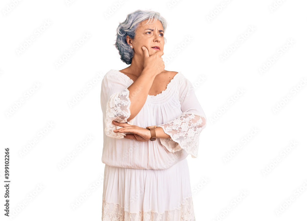 Senior woman with gray hair wearing bohemian style with hand on chin thinking about question, pensive expression. smiling with thoughtful face. doubt concept. Senior woman with gray hair wearing bohemian style with hand on chin thinking about question, pensive expression. smiling with thoughtful face. doubt concept.