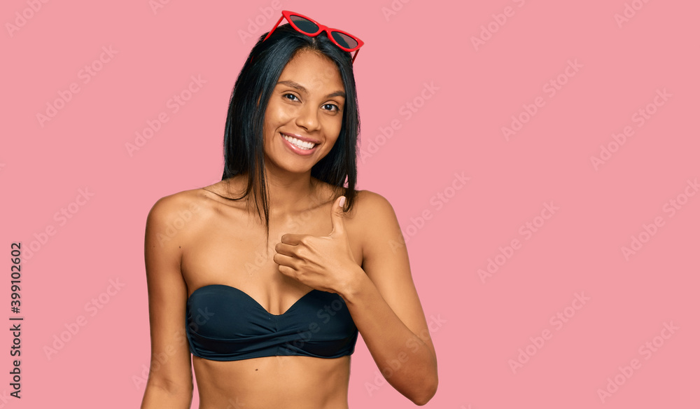 Young african american woman wearing bikini doing happy thumbs up gesture with hand. approving expression looking at the camera showing success. Young african american woman wearing bikini doing happy thumbs up gesture with hand. approving expression looking at the camera showing success.