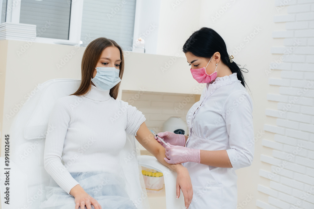 Vaccination of a girl against flu and coronavirus infection during a worldwide pandemic. The formation of the immune system and antibodies. Vaccination of a girl against flu and coronavirus infection during a worldwide pandemic. The formation of the immune system and antibodies.