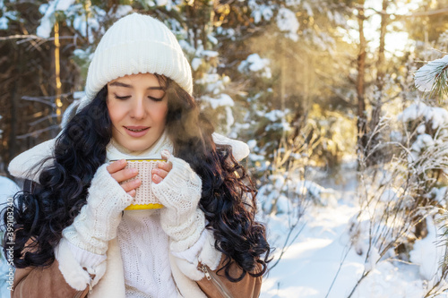 beautiful young woman drinking hot drink in a fabulous winter forest © serhio777