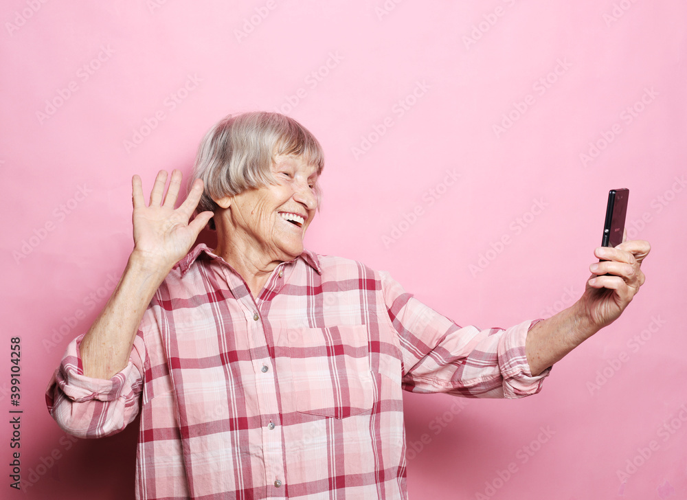 old grandmother is talking to her grandchildren by phone, smiling and greeting them. old grandmother is talking to her grandchildren by phone, smiling and greeting them.