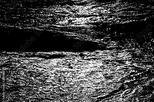 Night ripples of the ocean shiny surface. Reflection of moonlight in the dark abyss of waters. Dangerous sea depth for background. Gloomy stormy massive tide on the coast.Deep black vintage surf beach