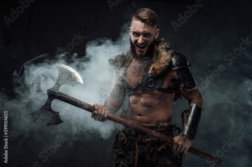 Barbaric scandinavian seafarer armed with two handed axe and dressed in fur with light armour holding huge axe in fog.