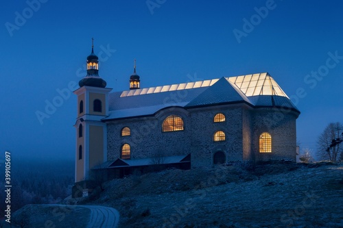 Baroque church of the Assumption of the Virgin Mary in Neratov built between 1723 and 1733. The church has a unique roof made of glass in the shape of a cross. Christmas, first snow in winter, Czechia photo