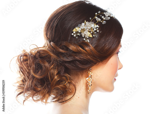 Wedding luxury hairstyle with a diadem. Back view. Young bride posing on a white background.