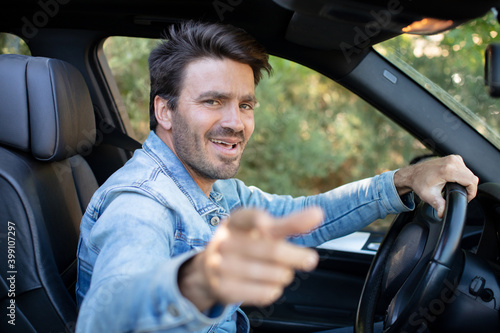 man in car pointing finger to you