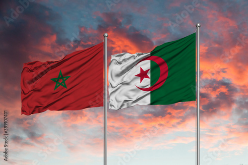 Flag of Morocco and Algeria waving together in the blue sky photo