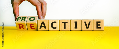 Reactive or proactive symbol. Businessman hand turns cubes and changes the word reactive to proactive. Business and reactive or proactive concept. Beautiful white background, copy space.