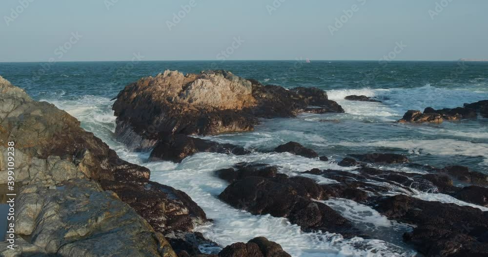 Big sea waves splash against rock on island Big sea waves splash against rock on island