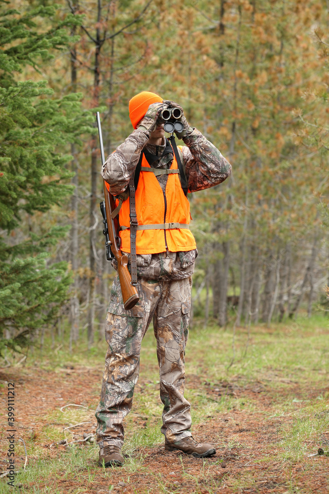 adult deer hunter looking through binoculars adult deer hunter looking through binoculars