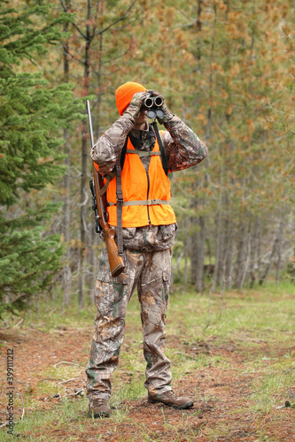 adult deer hunter looking through binoculars