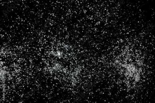 Sugar crystals scattered on a black background.