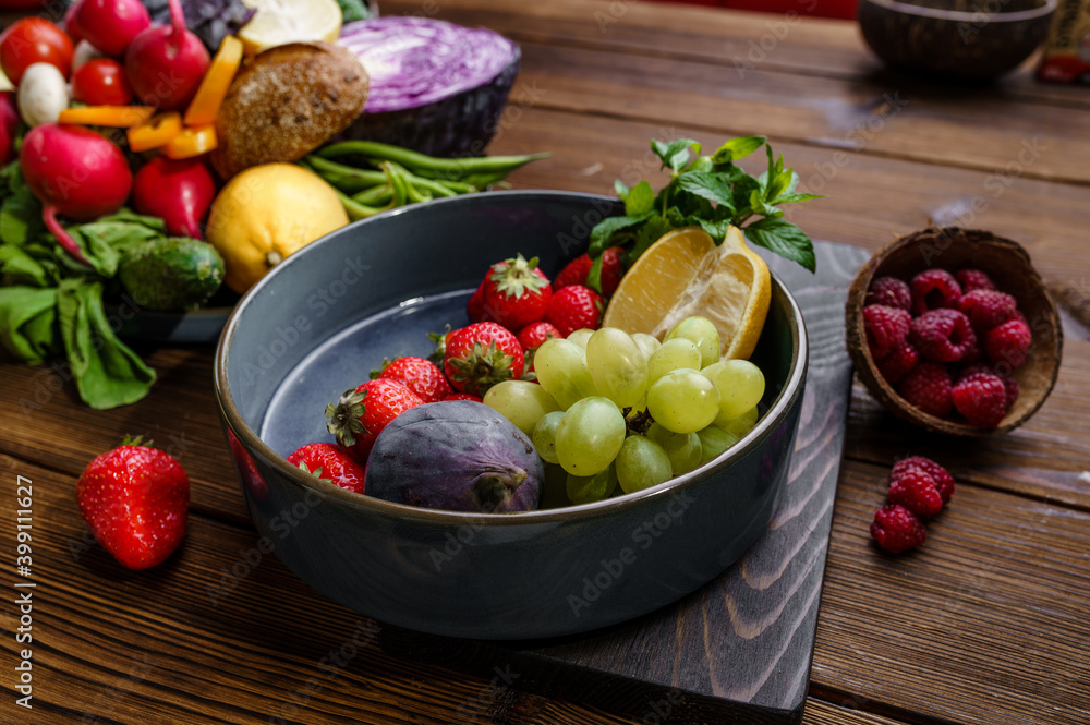 Fruits and berries in plate on wooden background Fruits and berries in plate on wooden background