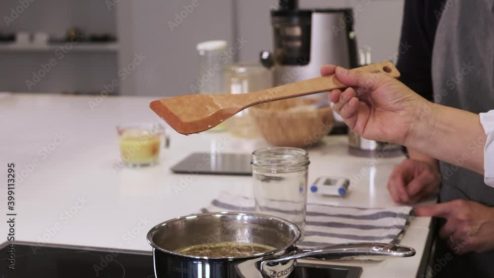 Drop of Sweet Ginger Syrup Dripping From Wooden Spatula into Pan in Slow Motion Drop of Sweet Ginger Syrup Dripping From Wooden Spatula into Pan in Slow Motion