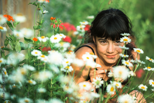 Teen girl outdoor among green wildflowers.