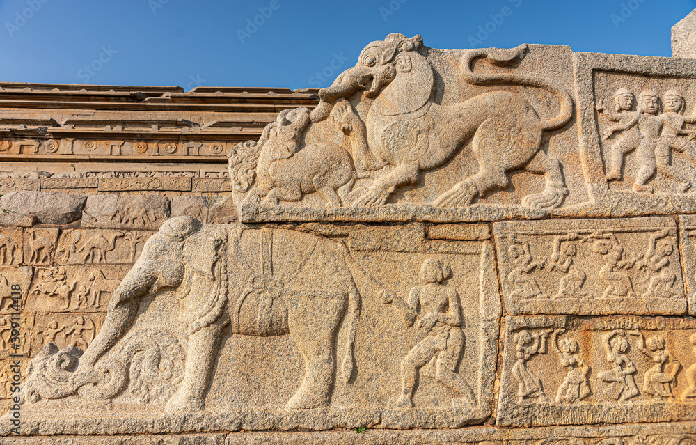 Hampi, Karnataka, India - November 4, 2013: Part of base of Mahanavami Dibba or the Dussehra Platform. Monumental sculptures as side of stairway show elephant, dancing women,  and othr beasts.