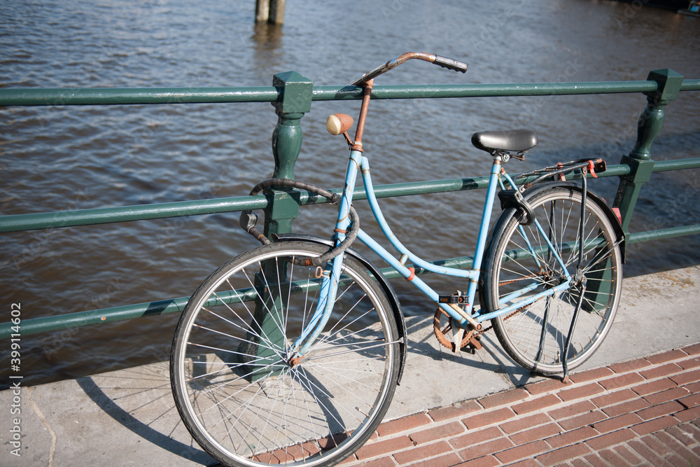 Rusty old bike locked to bridge in Amsterdam stock picture