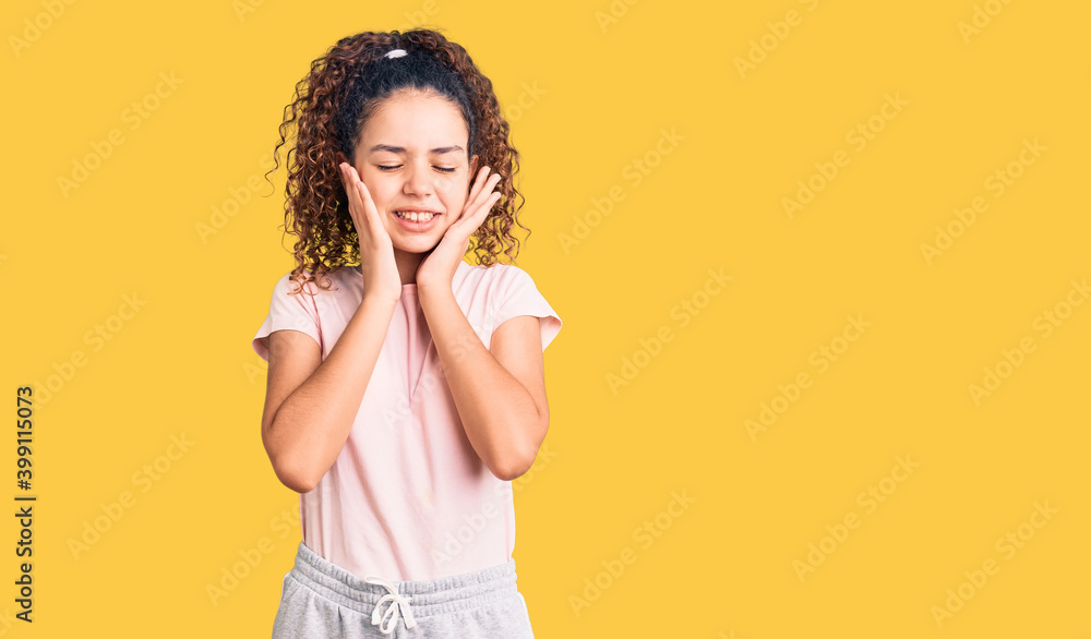 Beautiful kid girl with curly hair wearing casual clothes covering ears with fingers with annoyed expression for the noise of loud music. deaf concept. Beautiful kid girl with curly hair wearing casual clothes covering ears with fingers with annoyed expression for the noise of loud music. deaf concept.