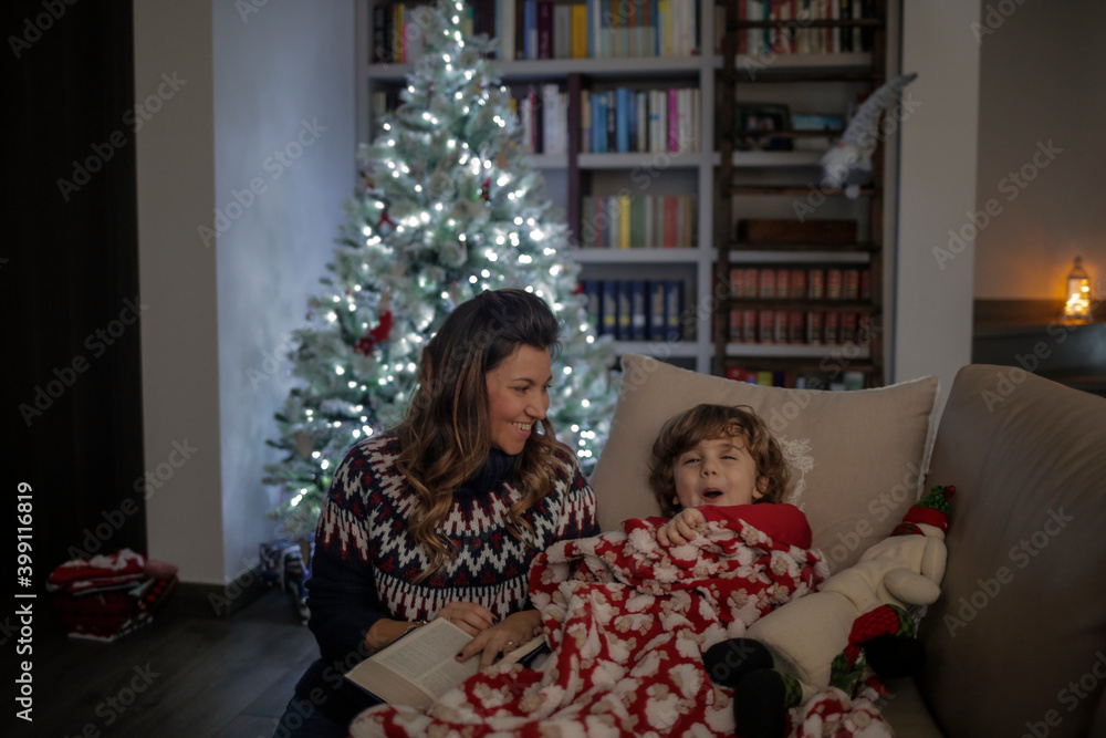 Mom and son are reading a book before sleeping