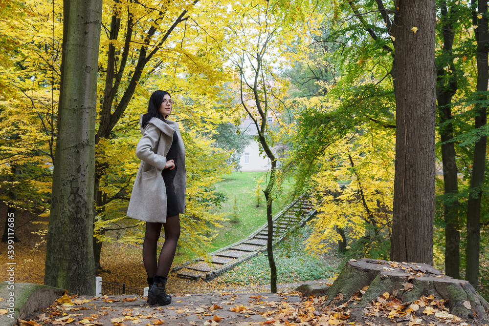 young girl in a gray coat stands on an alley young girl in a gray coat stands on an alley