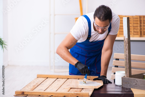 Young male contractor working in workshop