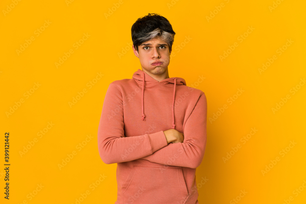 Young skinny hispanic man blows cheeks, has tired expression. Facial expression concept. Young skinny hispanic man blows cheeks, has tired expression. Facial expression concept.