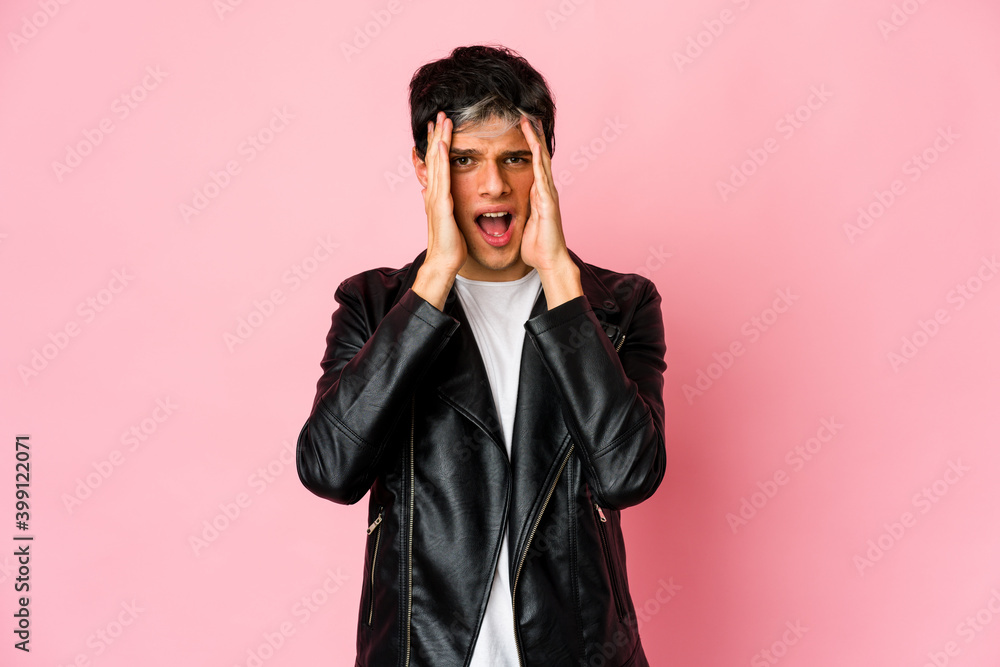 Obraz premium Young skinny hispanic man having fun covering half of face with palm.