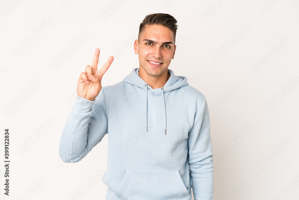 Young caucasian handsome man isolated joyful and carefree showing a peace symbol with fingers. Young caucasian handsome man isolated joyful and carefree showing a peace symbol with fingers.