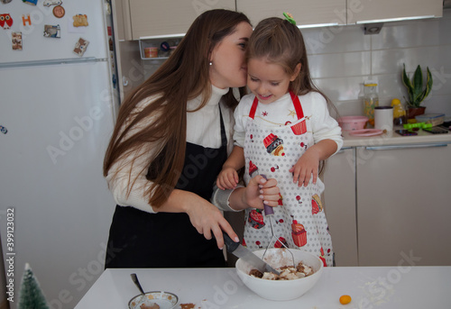 Mother and a little child cooking Christmas ginger bread. Family cooking concept. photo