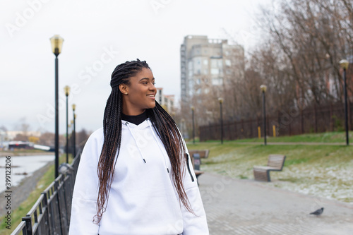 happy African American woman in a Park in a white hoodie © vilma3000