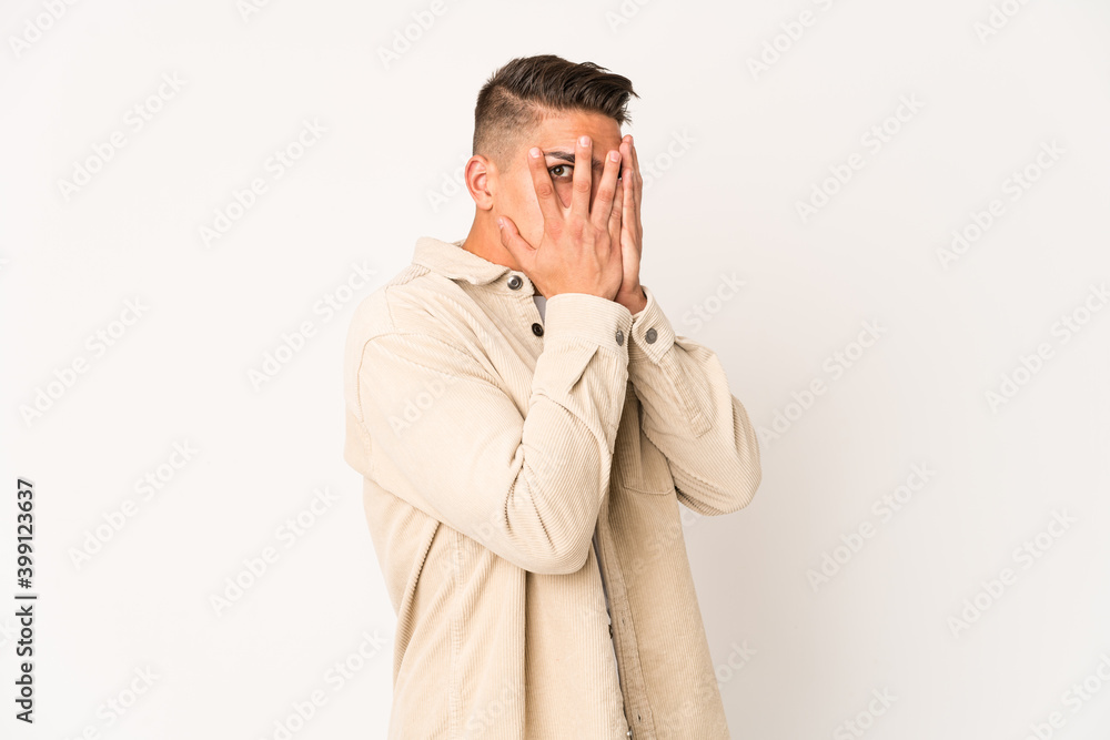 Young caucasian handsome man isolated blink through fingers frightened and nervous. Young caucasian handsome man isolated blink through fingers frightened and nervous.