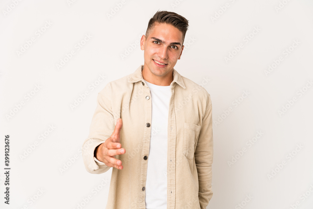Young caucasian handsome man isolated stretching hand at camera in greeting gesture. Young caucasian handsome man isolated stretching hand at camera in greeting gesture.
